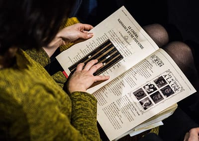 Une femme tient dans ses mains un des livrets d'activités prévus pour le "Ciné Mystères" - escape game au cinéma